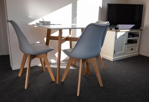 two chairs sitting next to a table with a television at Guest Suite in Peaceful Location Roxburgh in Dumbarton