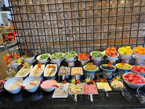 a buffet of food with bowls of vegetables and fruits at Puding Hotel in Antalya