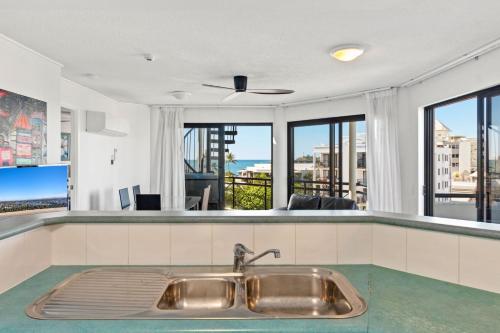 a kitchen with a sink and views of the city at Caribbean 66 in Mooloolaba