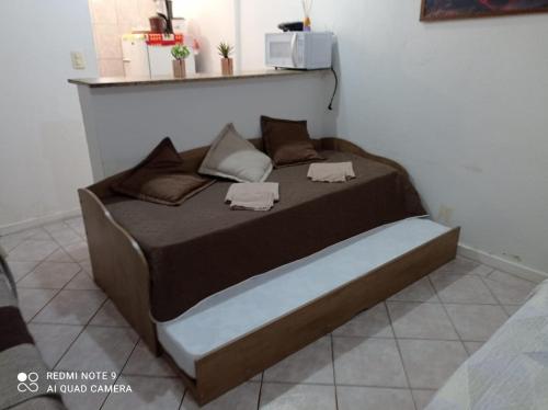 een groot bed in een kamer met avertisementatron bij STUDIO Centro Lacerda in Campos dos Goytacazes