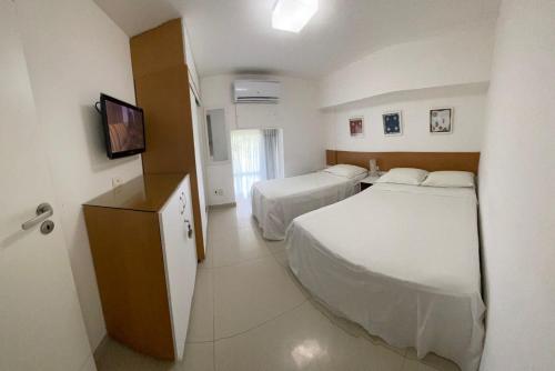 Habitación de hotel con 2 camas y TV en Flat Beira Mar Ancorar Porto de Galinhas, en Porto de Galinhas