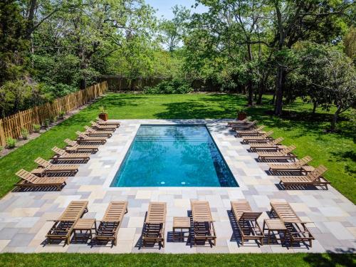 a pool with chaise lounge chairs and a bunch ofitures at The Peninsula in Cape May Court House