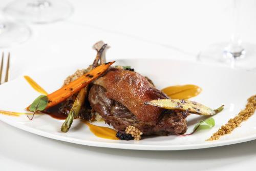 a plate of food with a piece of meat and carrots at The Peninsula in Cape May Court House
