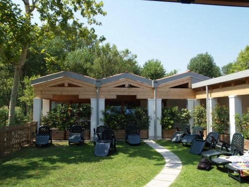 a patio area with chairs, tables and umbrellas at Camping Venezia Village in Mestre