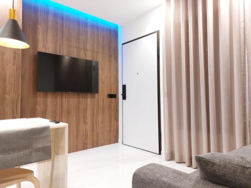 a living room with a tv and a sliding glass door at Liris Holiday Apartments in Nazaré