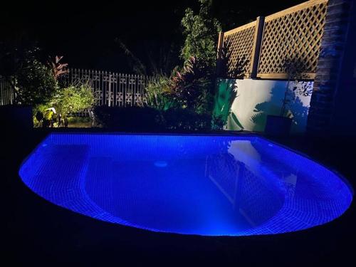 una piscina illuminata di notte in blu di Casa Flor de Pajaro, vistas panorámicas increíbles al lago a Suchitoto