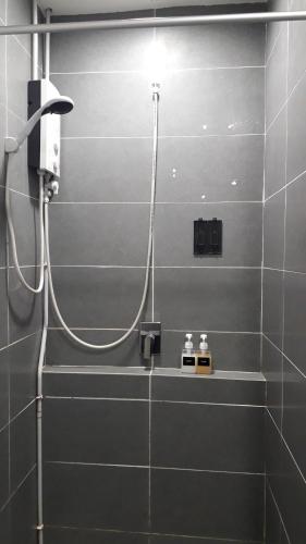 a bathroom with a shower with a light on the wall at BS City Homestay1 - Miri Times Square in Miri