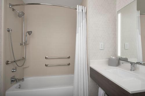 a bathroom with a tub and a sink and a shower at Holiday Inn Express & Suites Knoxville-Clinton by IHG in Clinton