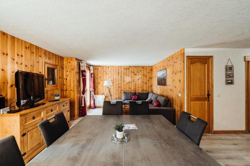 una sala da pranzo con tavolo e divano di Grazioso appartamento con balconi a 5 minuti dalla cabinovia Bettex a Saint-Gervais-les-Bains