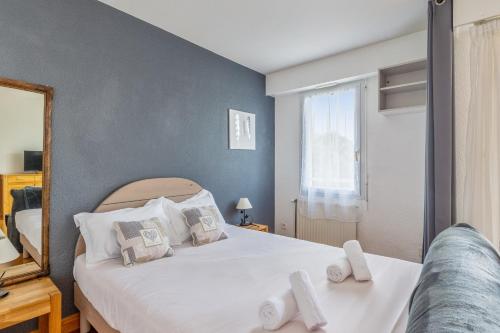a bedroom with a bed with white sheets and a window at Appartement Petit coin de paradis - Welkeys in La Rochelle