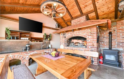 a living room with a brick fireplace and a wooden table at Nice Home In Nova Diklenica With Sauna in Nova Diklenica