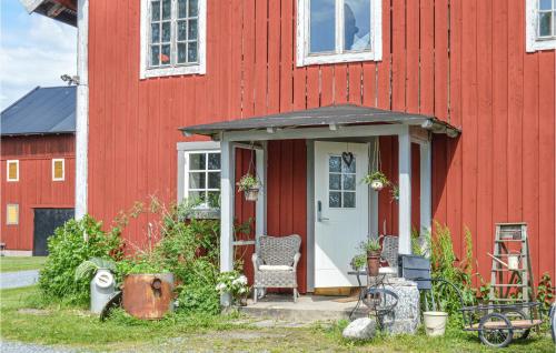 a red house with a white door and a chair at Nice Apartment In Malmköping With Sauna in Malmköping