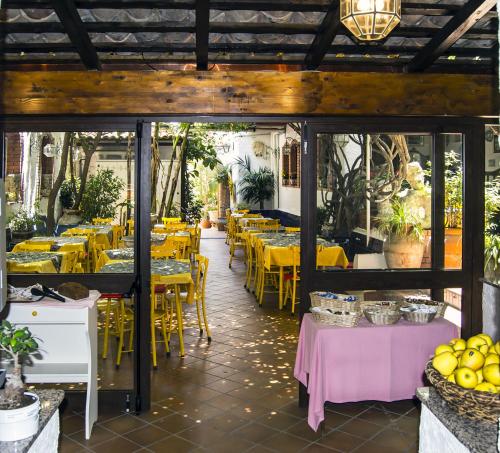 a restaurant with yellow tables and yellow chairs at Hotel da Peppe in Letojanni