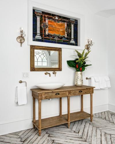 a bathroom with a sink and a mirror at The Peninsula in Cape May Court House