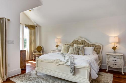 a white bedroom with a large bed and a window at The Peninsula in Cape May Court House