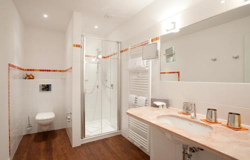 W łazience znajduje się prysznic, umywalka i toaleta. w obiekcie Hotel Gutenberg w mieście Westerland