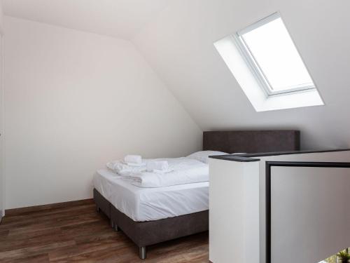 a bedroom with a bed and a skylight at Apartment Sneekermeer with Water Sports Access in Offingawier