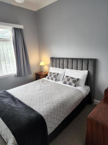 a bedroom with a large bed with two pillows at Gardner Court Motel in Napier