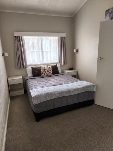 a bedroom with a large bed in front of a window at Gardner Court Motel in Napier