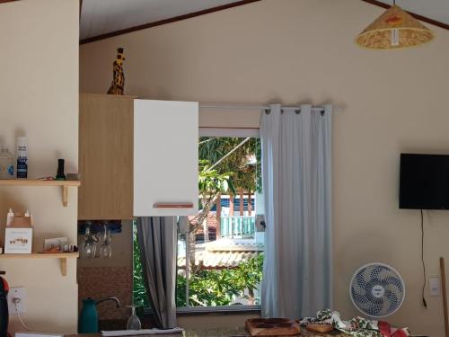 uma cozinha com uma porta aberta para um quintal em Flat do Léo em Praia de Araçatiba
