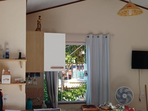 a kitchen with a door open to a yard at Flat do Léo in Praia de Araçatiba