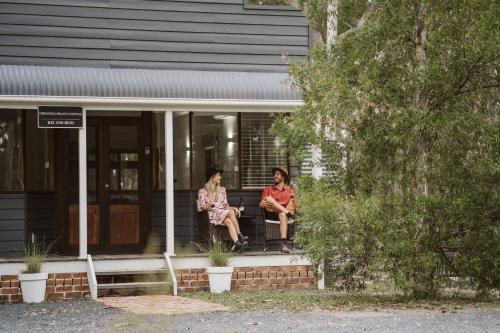 two women sitting on the porch of a house at Bay and Bush Cottages Jervis Bay in Huskisson