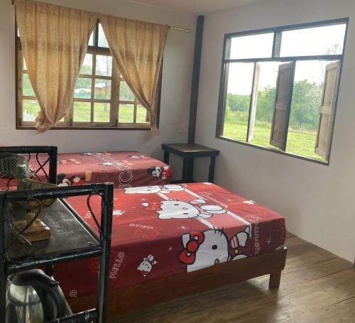 a bedroom with a bed with a hello kitty blanket at Lek's Issan Home and Travel in Ban Kut Khaen