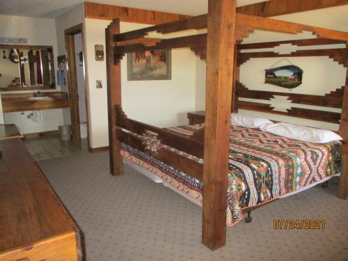 a bedroom with a large wooden bed in a room at Sundown Motor Lodge in Lincoln