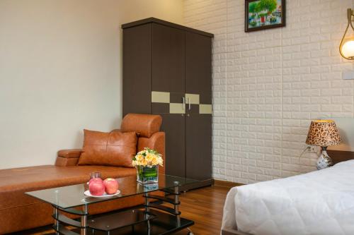 a room with a bed and a couch and a table at New Airport Hotel in Noi Bai