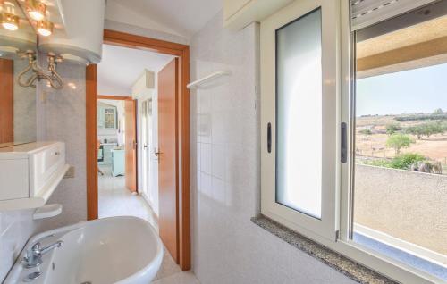 a bathroom with a white sink and a window at Casa Aurora in Donnalucata