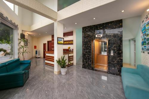 a lobby with a blue couch and a wall at New Airport Hotel in Noi Bai