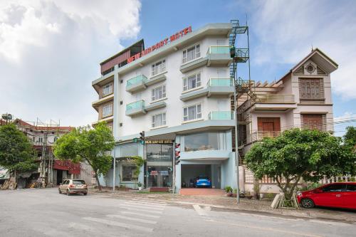 a large white building on the side of a street at New Airport Hotel in Noi Bai