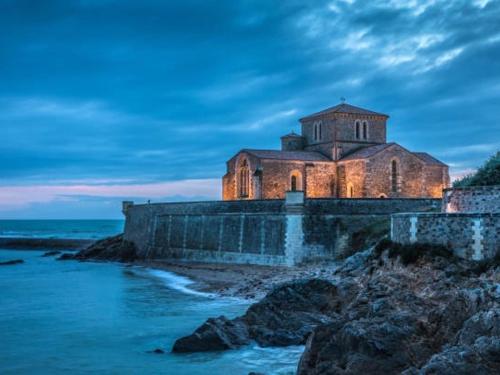 - un vieux bâtiment sur une falaise à côté de l'océan dans l'établissement Charmant T2, terrasse privative, proche plage et commerces - Quartier des Présidents, Les Sables d'Olonne - FR-1-325-124, à Les Sables-dʼOlonne