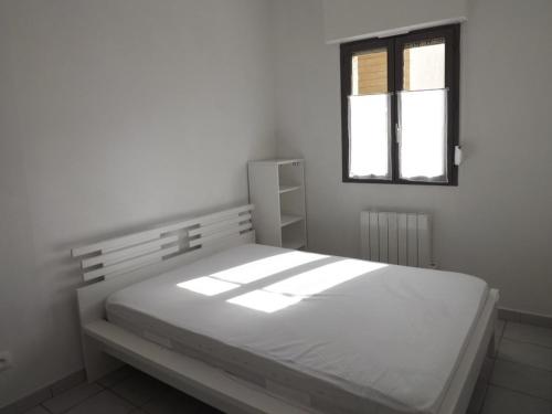 une chambre blanche avec un lit et une fenêtre dans l'établissement Appartement T2 en RDC, Proche Plage et Commerces, Idéal pour Séjours en Bord de Mer - FR-1-646-30, à Berck-sur-Mer