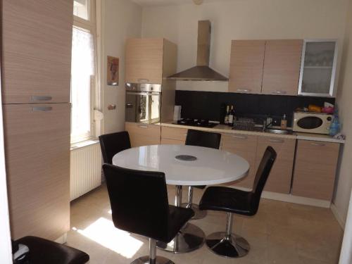 cocina con mesa blanca y sillas negras en Appartement Berck-Plage, 3 pièces, 4 personnes - FR-1-646-29, en Berck-sur-Mer