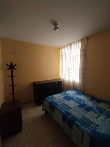 a bedroom with a blue bed and a window at Apartamentos en Huanchaco in Huanchaco