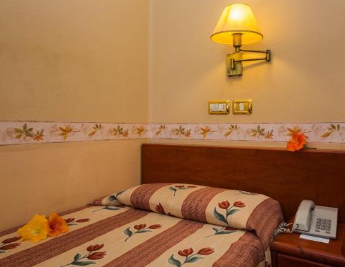 a bedroom with a bed with a telephone and a lamp at Hotel Monopol in Puerto de la Cruz