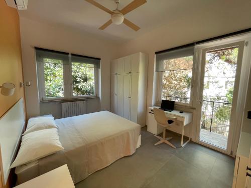 a bedroom with a bed and a desk and windows at Casa Marconi in Rome