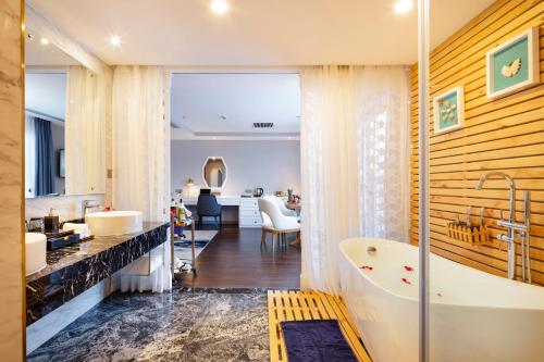 uma casa de banho com uma banheira e um lavatório em Erica Nha Trang Hotel em Nha Trang