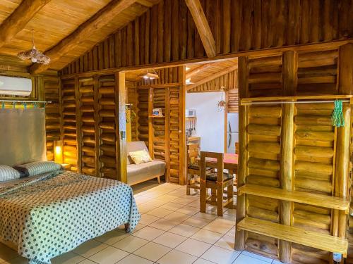 a bedroom with a bed in a room with wooden walls at Cabañas Lamaite in Sámara