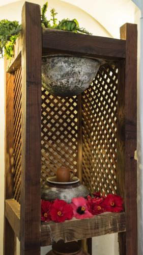 a wooden shelf with a bowl and red flowers at Hotel Monopol in Puerto de la Cruz
