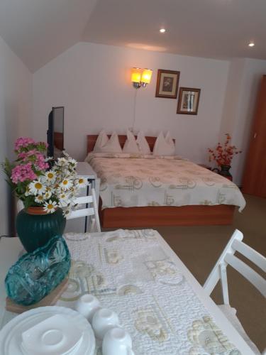 ein Wohnzimmer mit einem Bett und einem Tisch mit einem sidx sidx in der Unterkunft Pensiunea Floare de Colt in Sinaia
