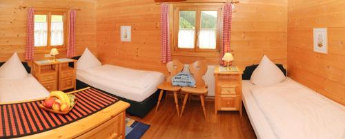 a room with two beds in a wooden cabin at Brücklmeier Ferienwohnungen in Gargellen