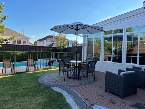 a patio with a table and chairs and an umbrella at Frisco finest home, large, pool, no parties! in Frisco