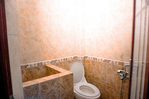 スラカルタにあるHotel Laweyan Soloのタイル張りの部屋のバスルーム(トイレ付)