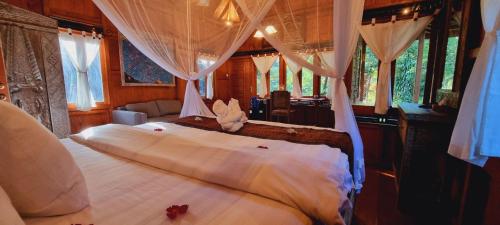 a bedroom with a large bed with a canopy at Avalon Ubud Castle & SPA in Ubud