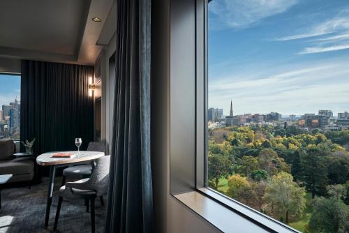a room with a table and a large window at Pullman Melbourne On the Park in Melbourne