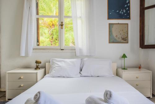 a bedroom with a white bed and a window at Mola Home by halu! Villas in Mola Kalyva