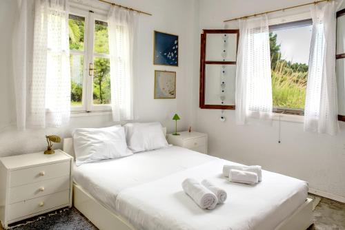 a bedroom with a bed with two towels on it at Mola Home by halu! Villas in Mola Kalyva