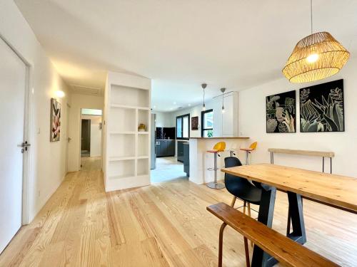 une cuisine et une salle à manger avec une table et des chaises en bois dans l'établissement Maison moderne idéale famille à 10 mn de la plage, à Labenne